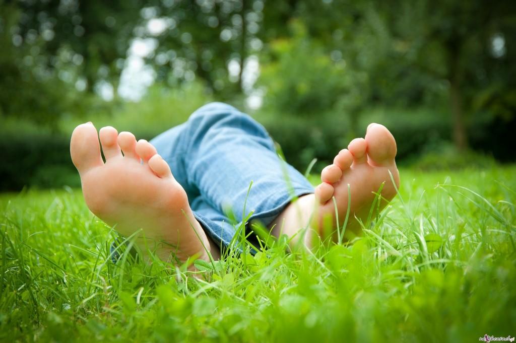 Feet of a young woman lying in the grass