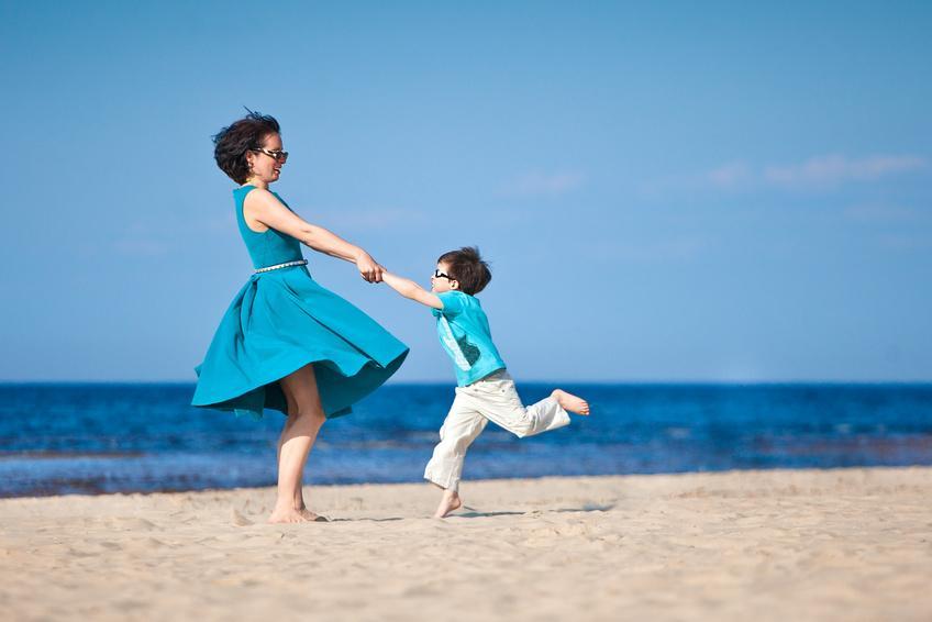 Mother and her little son playing on the beach