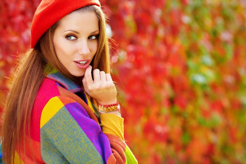 Beautiful elegant woman standing in a park in autumn