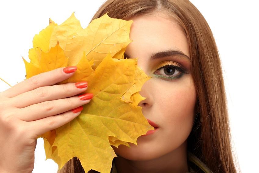 portrait of young woman with autumn maple leaves, isolated