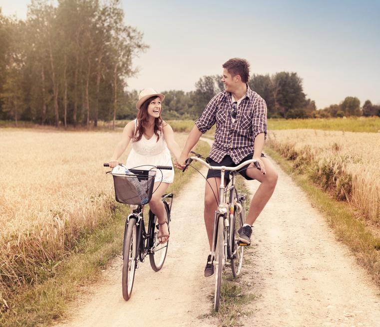 Happy couple cycling outdoors in summer