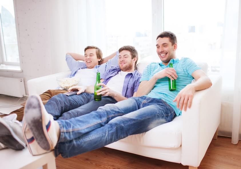 happy male friends with beer watching tv at home