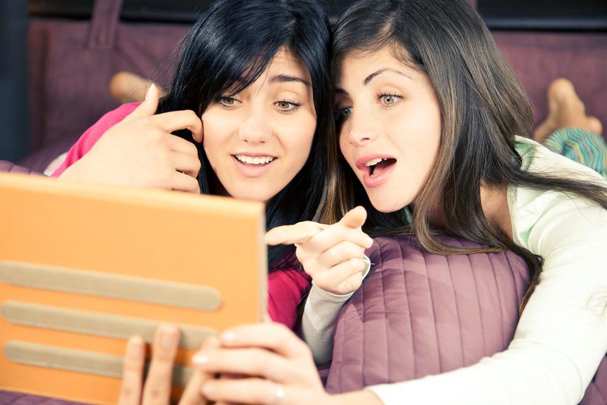 Girls surprised reading social network on tablet