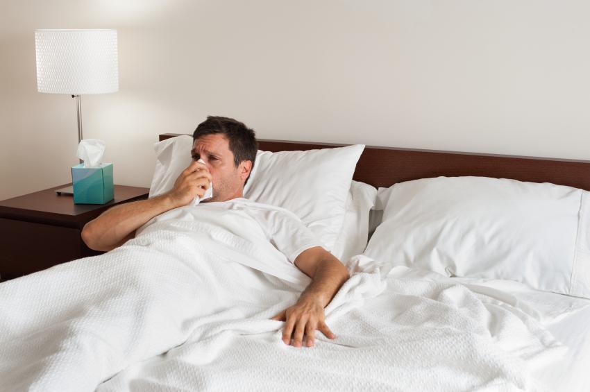 Sick Man in Bed Blowing Nose