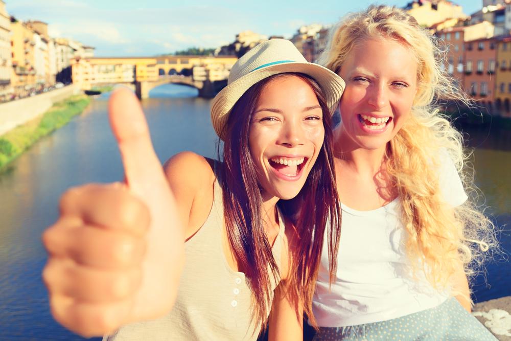 Girlfriends in city happy giving thumbs up