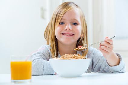 Beautiful child having breakfast at home.