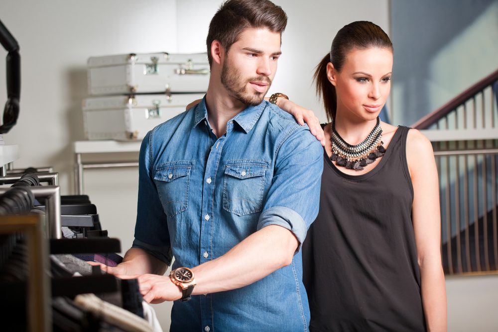 Very attractive, young and fashionable couple shopping clothes.