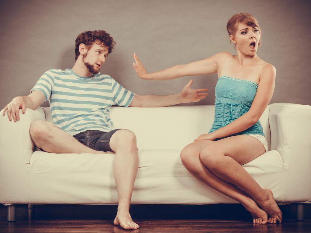 Man and woman in disagreement sitting on sofa