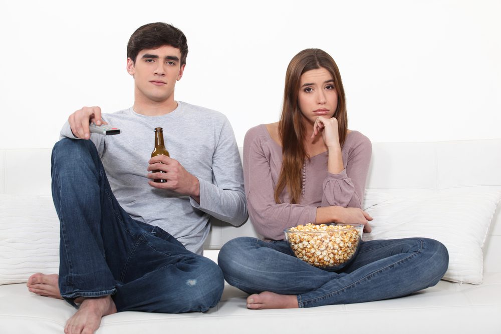 Bored man and woman watching TV