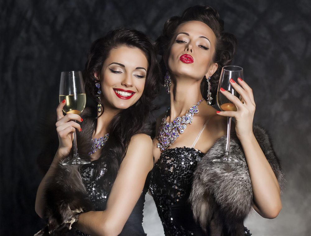 New Year's Eve of two beautiful young women with wineglasses of alcohol