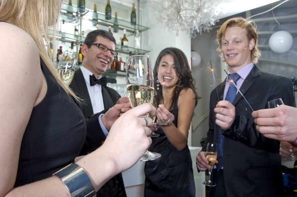 A group of five people celebrating new year at the bar in a club