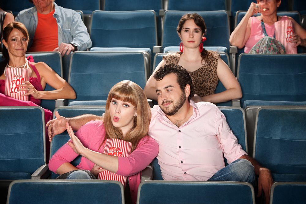 Young woman annoyed with boyfriend in theater