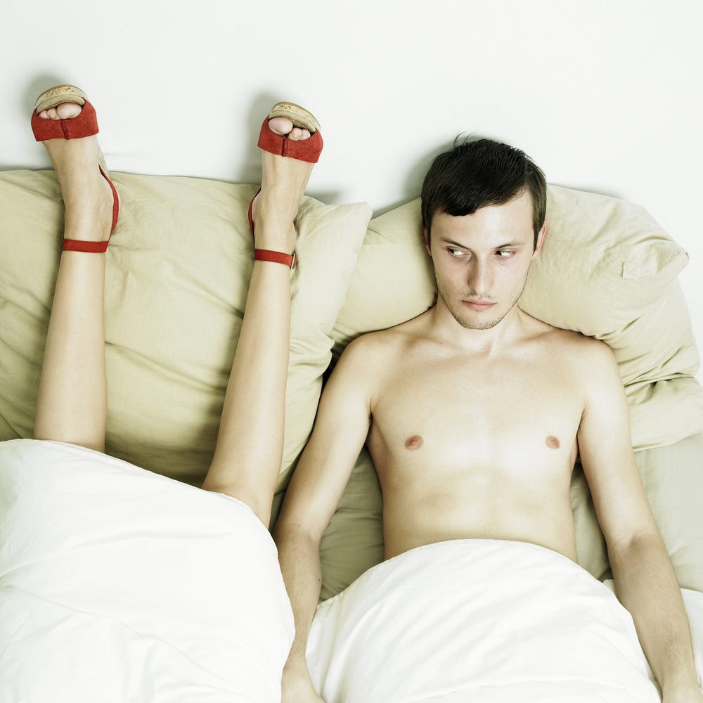 Fashion portrait of beautiful young lovers in bed