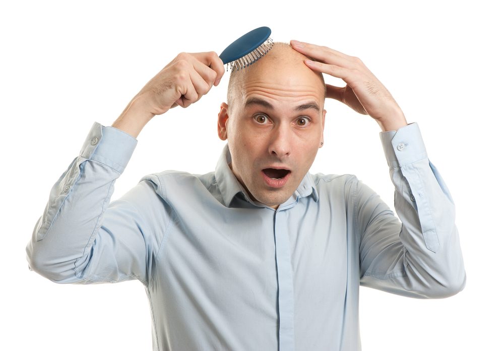 Shocked bald man holding comb