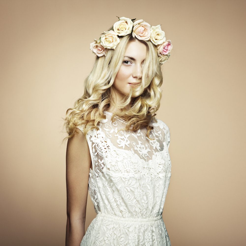 Portrait of a beautiful blonde woman with flowers in her hair. Fashion photo