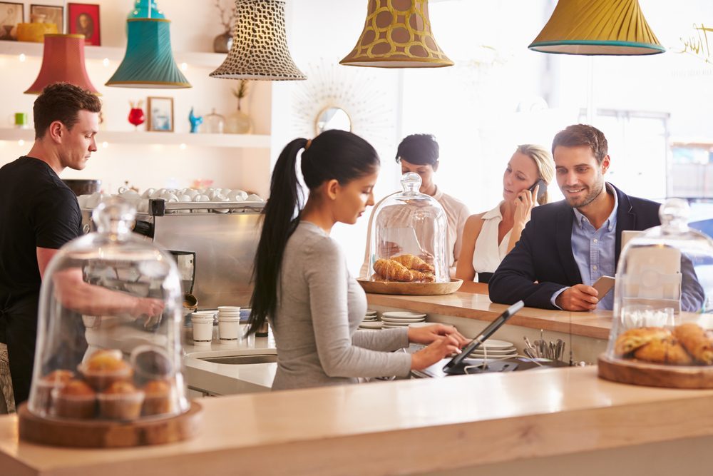 Young man ordering at the counter in a cafe