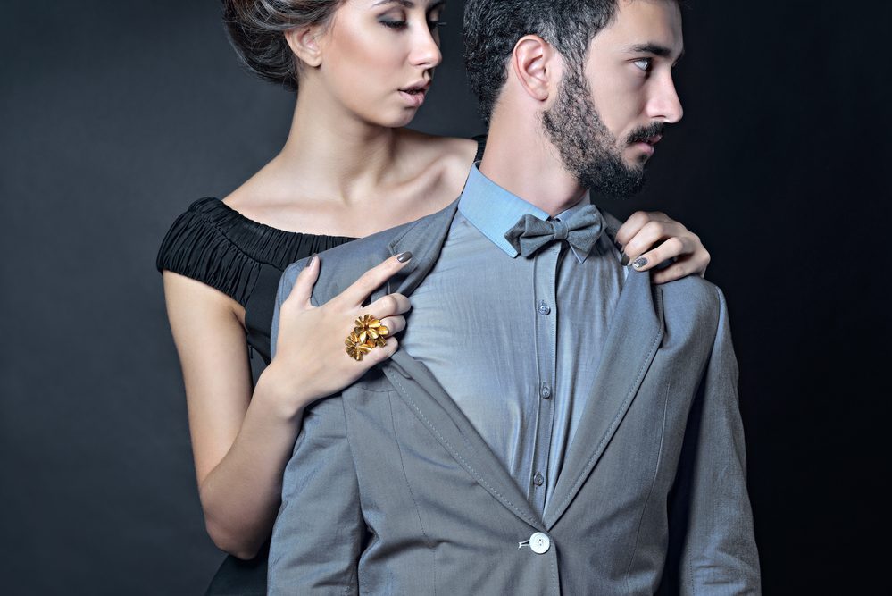 Beautiful lady in dress with guy in suit. Young couple is hugging each other. Portrait of girl with attractive body and boy indoors in passionate pose. Beauty woman with lace gown