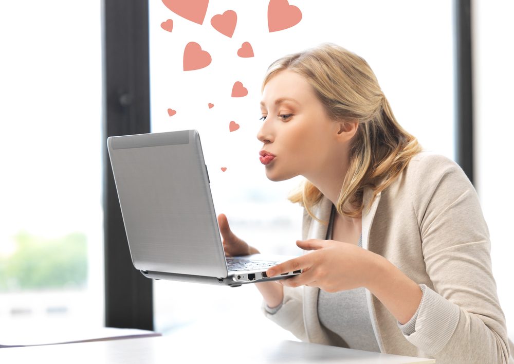 picture of woman with laptop computer sending kisses and hearts