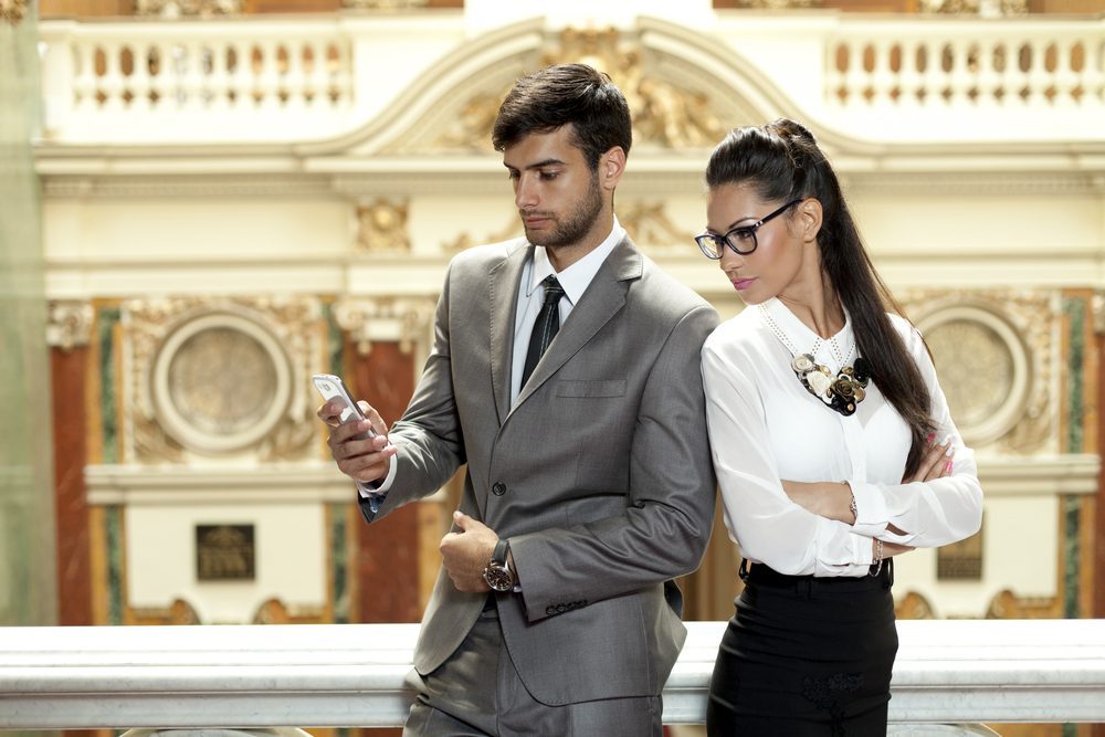 Jealous woman looking at her partner chatting on the phone