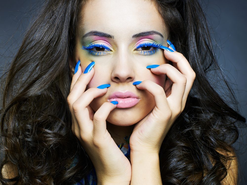 Photo of a young beautiful woman with bright makeup and manicure