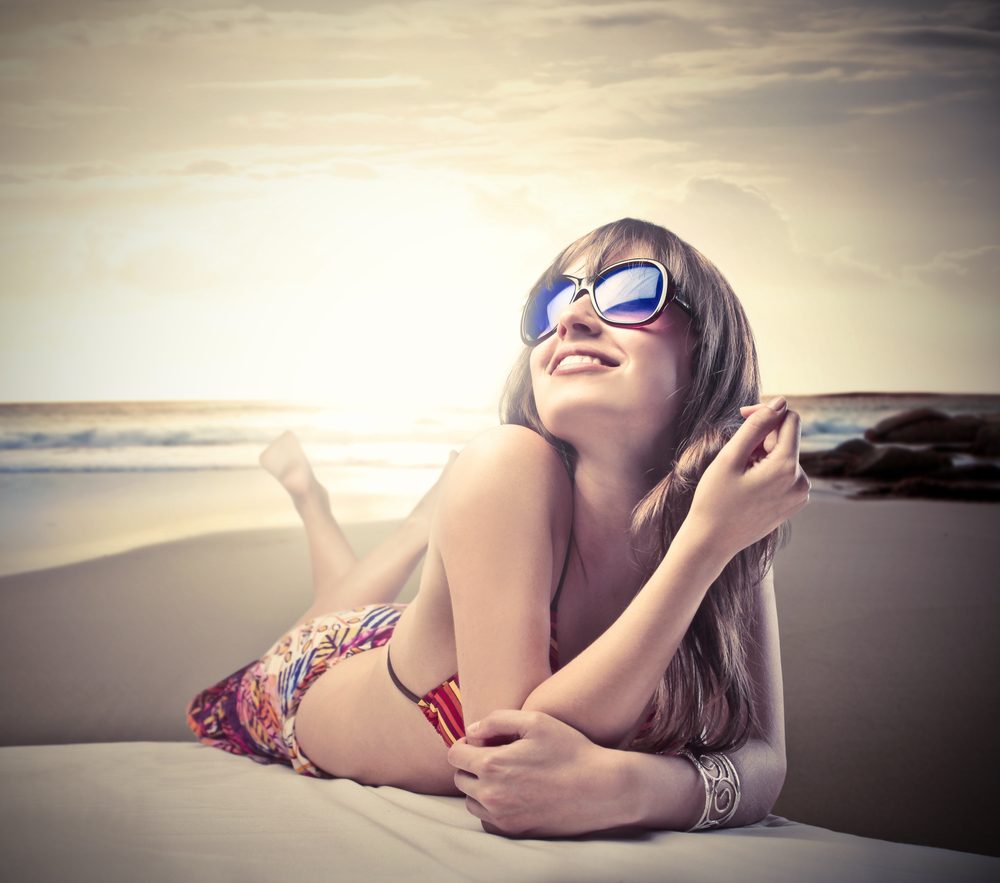 Smiling beautiful woman lying on a beach