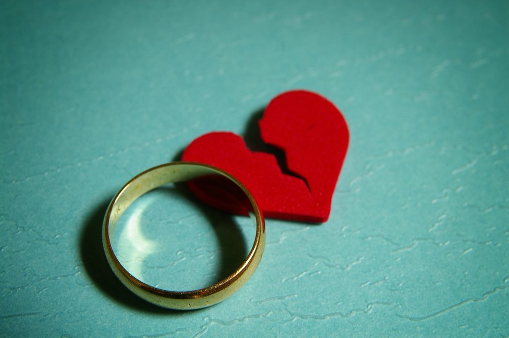 wedding ring and broken red heart - divorce concept