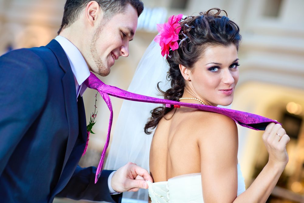 Young wedding couple indoors funny portrait.