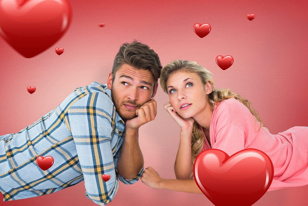 Attractive young couple lying and thinking against red vignette