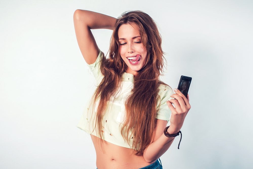 Happy smiling woman taking selfie with smartphone