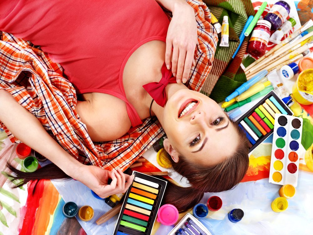 Artist woman lying on paint palette.