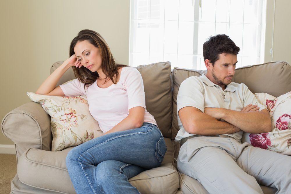 Unhappy couple not talking after an argument in living room at home