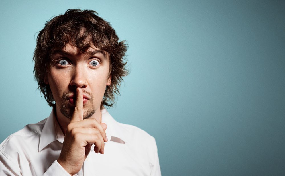 Closeup portrait of handsome young shocked business man, silent young business man shows the gesture of silence. Positive human emotion, facial expression sign symbol.