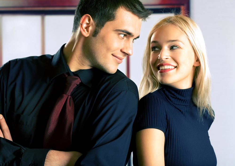 Young attractive smiling couple or business people