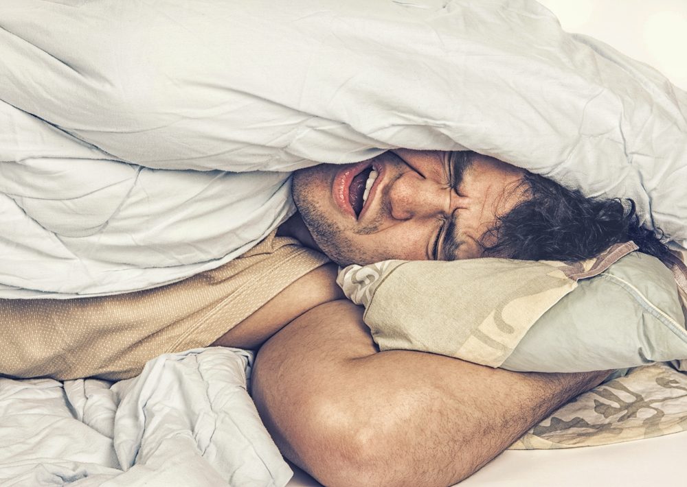 Young man in bed , trying to sleep