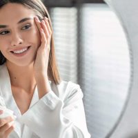 kobieta smaruje twarz kremem