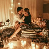 Para w pokoju pełnym świec przytulająca się na podłodze