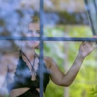 kobieta patrząca przez wiosenne okno