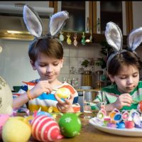 dzieci malujące w kuchni jajka na Wielkanoc